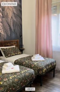 a hotel room with two beds with towels on them at B&B La Fenice in Bologna
