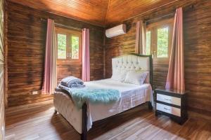 a bedroom with a bed in a room with wooden walls at Encantadora Villa con piscina. in Santiago de los Caballeros