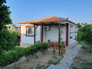 una pequeña casa con mesa y techo en Christina Apartment en Ágios Konstantínos