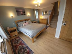 a bedroom with a bed and a stairway at Looe, Cornwall, Langunnett Cottage in Looe