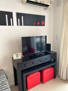 a black dresser with a flat screen tv on a wall at Thames Suite Plaza Italia in Buenos Aires