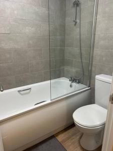 La salle de bains est pourvue d'une douche, de toilettes et d'une baignoire. dans l'établissement Comfortable & Spacious Apartment, à Stoke-on-Trent