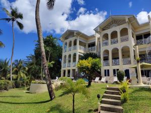 a large building with palm trees in front of it at Queen Angel Suite. Stunning Apartment on Grafton Beach with Direct Beach Access in Black Rock