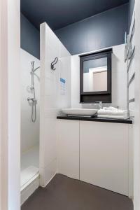 La salle de bains blanche est pourvue d'un lavabo et d'un miroir. dans l'établissement République - meublé calme sur la presqu'île, à Lyon