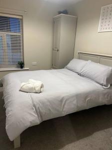a large white bed with a white pillow on it at Comfortable & Spacious Apartment in Stoke on Trent