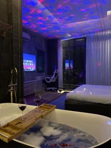 Khánh Nguyễn Luxury Apartment, balcony street view, large bathtub في مدينة هوشي منه: غرفة في الفندق مع حوض استحمام وكأسين من النبيذ
