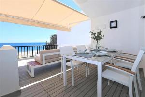 biały stół i krzesła na balkonie z widokiem na ocean w obiekcie Beachhouse GALORE w mieście Estepona