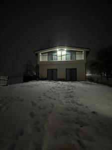 Una casa en la nieve por la noche en Cabana din Deal en Băile Borşa