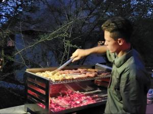 Een jongen kookt eten op een grill. bij Taaibos Bush Lodge in Hoedspruit