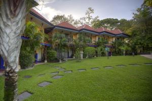 a building with a lawn in front of it at Hotel Cuna del Angel in Uvita