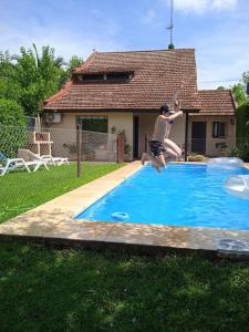 um homem a saltar para uma piscina com um disco voador em Casa Los Trinos em Lobos