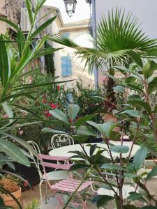 een patio met een roze stoel en een aantal planten bij Maison Consulaire Chambre d hote de charme in Valros