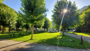 un parque con árboles y una caravana estacionada junto a una carretera en Camping Llavorsi, en Llavorsí