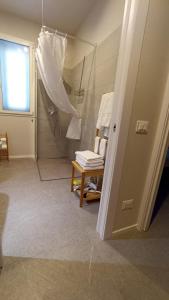 a bathroom with a shower and a chair with an umbrella at Appartamento B&B Cà Betty in Sacerno