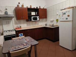 a kitchen with a table and a white refrigerator at Vila Ana-Maria in Sinaia