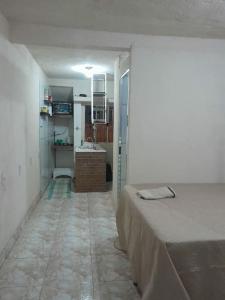 um pequeno quarto com uma cama e uma cozinha em Mini Casa em Arraial d'Ajuda em Porto Seguro