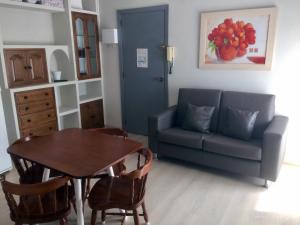 sala de estar con sofá azul y mesa en Apartamentos Angelito Playa América, en Nigrán