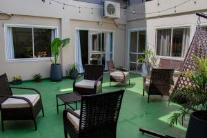 eine Terrasse mit Stühlen, Tischen und Pflanzen in der Unterkunft Hotel Rio Dorado in Encarnación