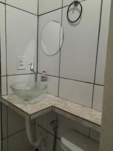 La salle de bains est pourvue d'un lavabo et de toilettes. dans l'établissement Mini Casa em Arraial d'Ajuda, à Porto Seguro