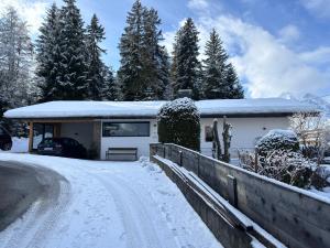 une maison dans la neige avec une allée dans l'établissement Haus Drescher, à Leutasch