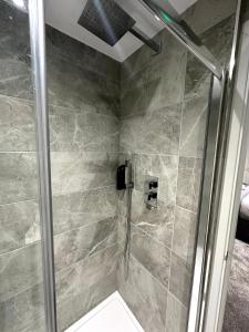 a shower with a glass door in a bathroom at Gainsborough Lodge in Horley