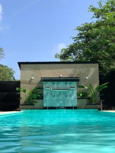 a swimming pool with a fountain in front of a house at Tayrona Suites in El Zaino