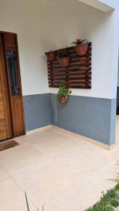 a room with potted plants on the side of a wall at Casa na martim de Sa in Caraguatatuba