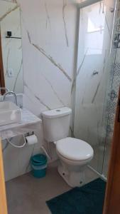 a bathroom with a toilet and a sink and a shower at Casa na martim de Sa in Caraguatatuba