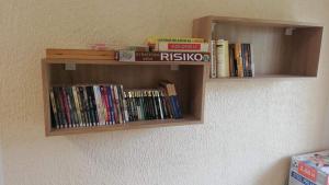 a book shelf filled with books on a wall at Seosko domaćinstvo Najdanović in Soko Banja