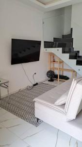 a living room with a bed and a flat screen tv at Casa na martim de Sa in Caraguatatuba