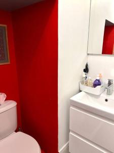 baño con aseo blanco y pared roja en Mini studio 12m2, Lyon4, centre CroixRousse, 2prs en Lyon