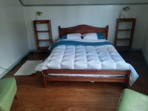 HOSTAL FERNANDO في فالديفيا: غرفة نوم بسرير كبير مع اطار خشبي