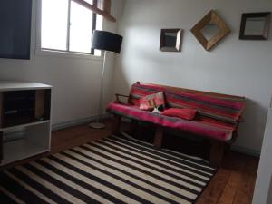 uma sala de estar com um sofá vermelho e um tapete em HOSTAL FERNANDO em Valdivia