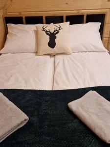 a bed with white pillows with a deer on it at Chochołowski Zakątek in Chochołów
