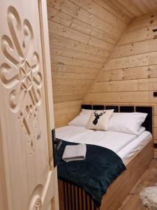 a bed in a room with a wooden ceiling at Chochołowski Zakątek in Chochołów