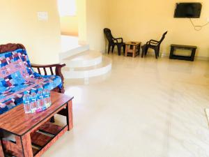 a living room with chairs and a table with water bottles at COORG STONE VILLA in Madikeri