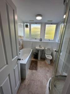 een badkamer met een bad, een toilet en een wastafel bij 3 bedroom garden house Maida Vale in Londen