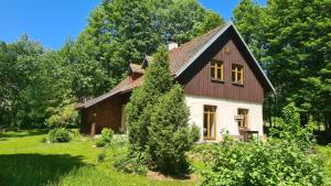 una casa con techo de gambrel en un patio verde en Chalupa Ostrůvek, en Tachov