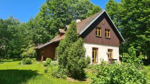 a house with a gambrel roof on a green yard at Chalupa Ostrůvek in Tachov