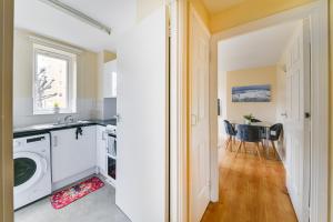 a kitchen and dining room with a washer and dryer at Amazing apartment in Canada Water - Free parking in London