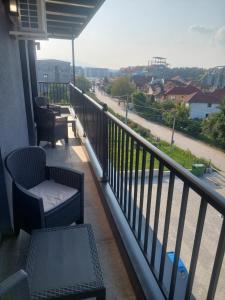 a balcony with chairs and a table and a view of a street at Apartman Andrea2 in Vrnjci