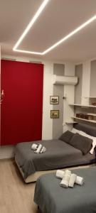 1 dormitorio con 2 camas y pared roja en AURY HOUSE - STATlON - -ViaDante-Platani- en Cremona