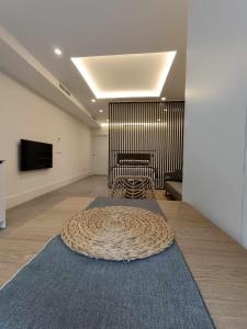 Habitación con una alfombra grande en el suelo y TV. en AT Presidente Nº3 apartamento privado completo en Sevilla