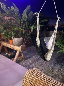 a hammock and a bench in a garden at Ti kaz coco in Saint-Leu
