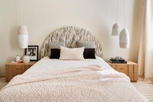 a bedroom with a large white bed with a wooden headboard at Appartement near the sea in La Goulette