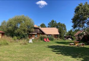 una casa con un patio con sillas rojas delante en Naturpark Ferienhaus, en Szalafő