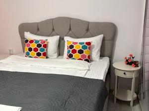 a bed with a gray headboard and pillows on it at Apartment Fire & Lux near the center in Razgrad