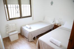 pokój z dwoma łóżkami, krzesłem i oknem w obiekcie Casa de playa, cerca de todo w mieście Los Narejos