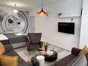 a living room with a couch and a tv on a wall at Apartment Fire & Lux near the center in Razgrad