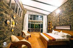 um quarto com uma cama e uma grande janela em Imbogo Diners and Lounge em Kisoro